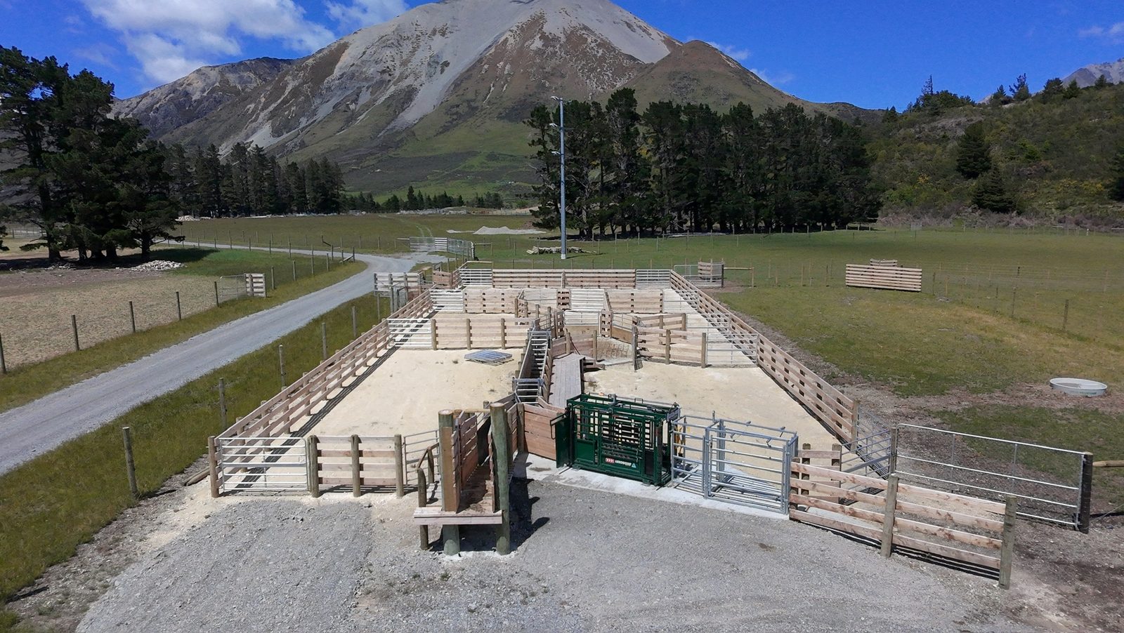 Aerial view of a completed timber stockyard and cattle race built by Jorgensen Fencing, Southern Alps behind